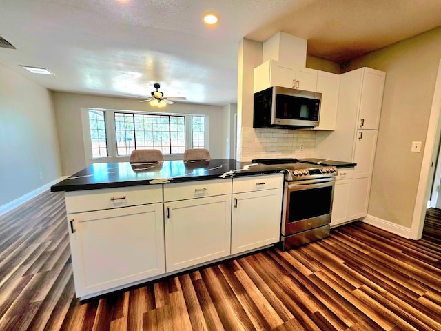 41549 Long Hollow Dr, Coarsegold, CA 93614 - kitchen with stainless steel appliances, dark countertops, dark wood finished floors, baseboards, and recessed lighting