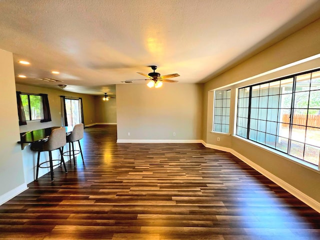41549 Long Hollow Dr, Coarsegold, CA 93614 - unfurnished living room with dark wood-style flooring, baseboards, recessed lighting, and a textured ceiling