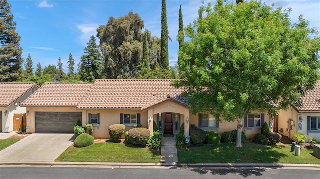 mediterranean / spanish home featuring an attached garage, stucco siding, driveway, and a front yard