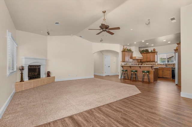 6458 N Warren Ave, Fresno, CA 93711 - unfurnished living room featuring ceiling fan, lofted ceiling, wood finished floors, arched walkways, and baseboards