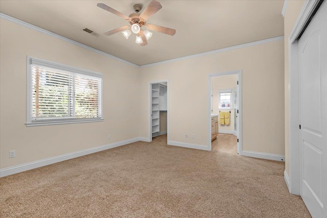 unfurnished bedroom featuring a closet, light carpet, ornamental molding, ensuite bath, and baseboards