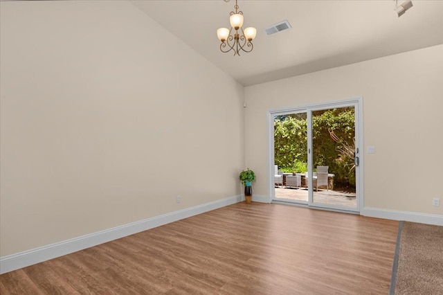 empty room featuring a chandelier, baseboards, lofted ceiling, and wood finished floors
