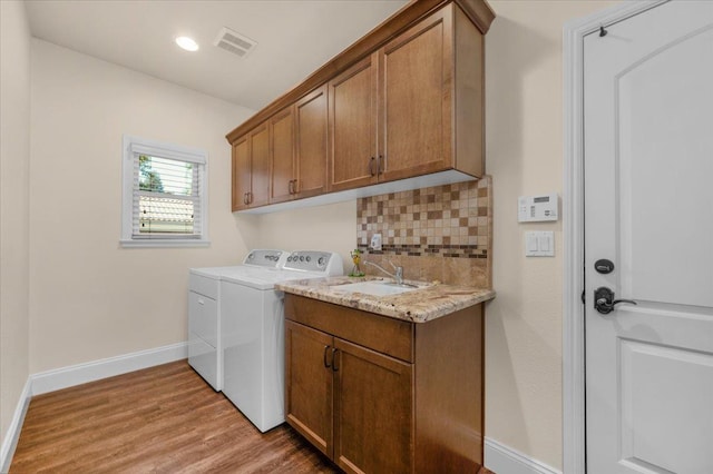 laundry room featuring independent washer and dryer, cabinet space, light wood finished floors, baseboards, and recessed lighting