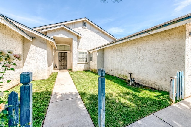 2670 N Katy Ave, Fresno, CA 93722 - doorway to property with a lawn and stucco siding