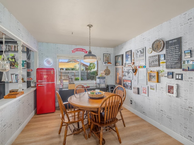 dining area with baseboards, wood finished floors, and wallpapered walls