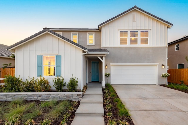 1179 Maclure Ave W, Madera, CA 93636 - view of front facade featuring board and batten siding, fence, an attached garage, and driveway