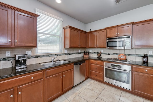 3507 Significant Way, Clovis, CA 93619 - kitchen featuring stainless steel appliances, a sink, dark stone counters, backsplash, and light tile patterned floors