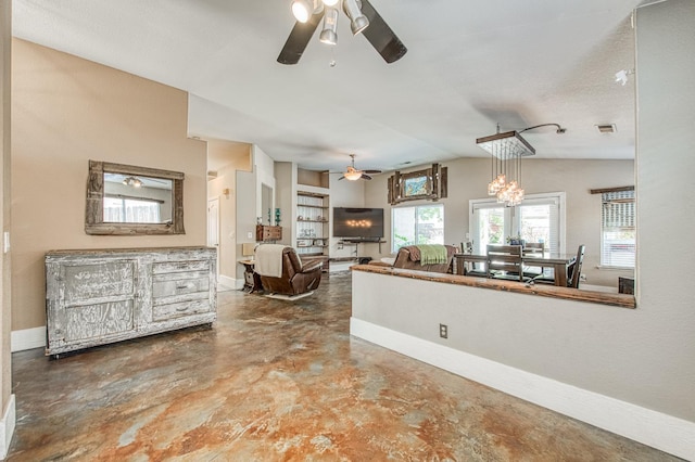 kitchen featuring ceiling fan, finished concrete floors, baseboards, and lofted ceiling