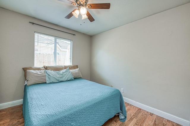 bedroom with baseboards, wood finished floors, and ceiling fan