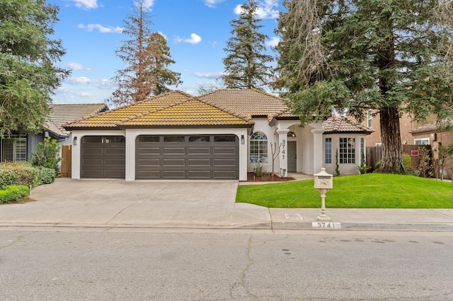 mediterranean / spanish-style home with an attached garage, driveway, stucco siding, and a tiled roof