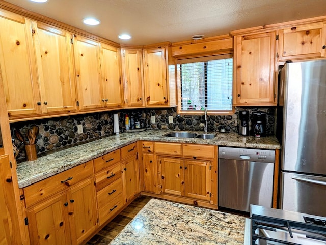 41016 Woodridge Ln, Shaver Lake, CA 93664 - kitchen featuring appliances with stainless steel finishes, a sink, dark wood finished floors, tasteful backsplash, and light stone counters