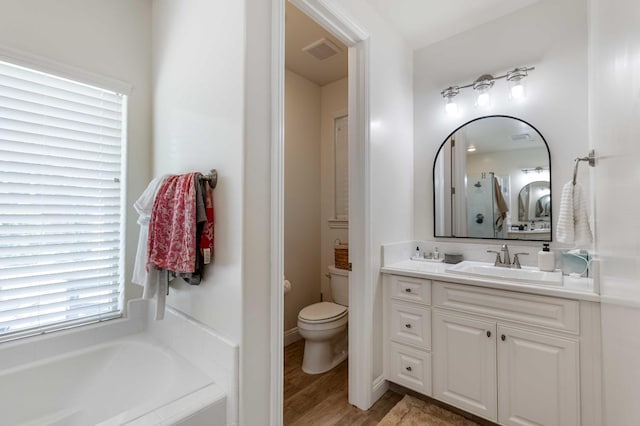 2506 20th Ave, Kingsburg, CA 93631 - bathroom featuring a garden tub, vanity, toilet, and wood finished floors