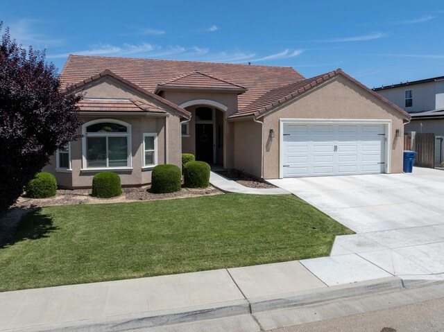 2506 20th Ave, Kingsburg, CA 93631 - view of front of property with an attached garage, concrete driveway, a front lawn, stucco siding, and a tile roof