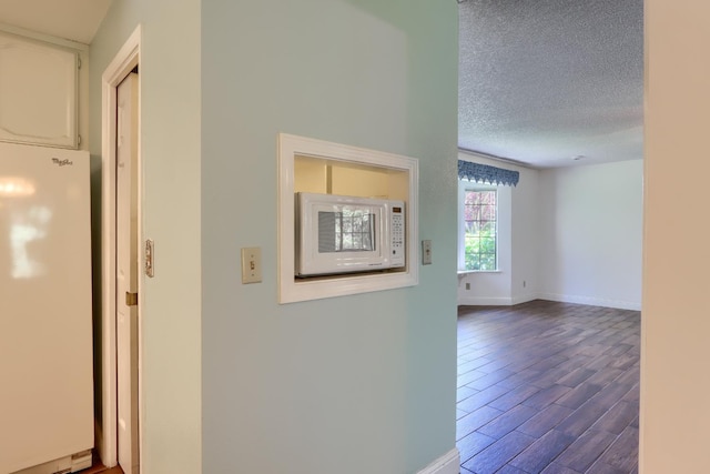 42177 Lone Olive Ln, Ahwahnee, CA 93601 - hallway with dark wood finished floors, a textured ceiling, and baseboards