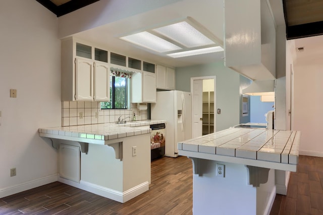 42177 Lone Olive Ln, Ahwahnee, CA 93601 - kitchen with tile counters, a peninsula, white refrigerator with ice dispenser, and a kitchen breakfast bar