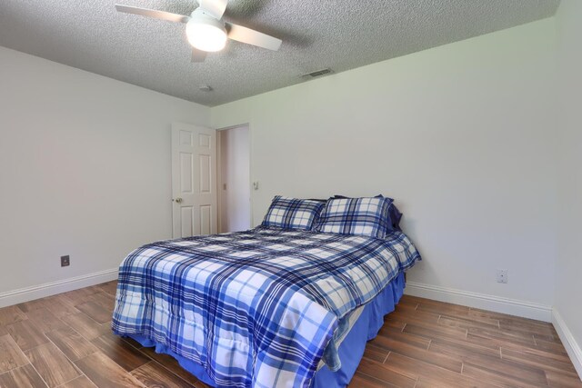 42177 Lone Olive Ln, Ahwahnee, CA 93601 - bedroom with baseboards, a textured ceiling, wood finished floors, and ceiling fan
