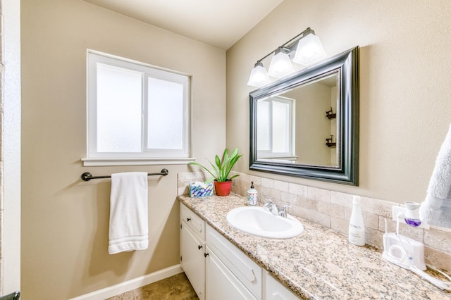 bathroom featuring vanity, backsplash, and baseboards
