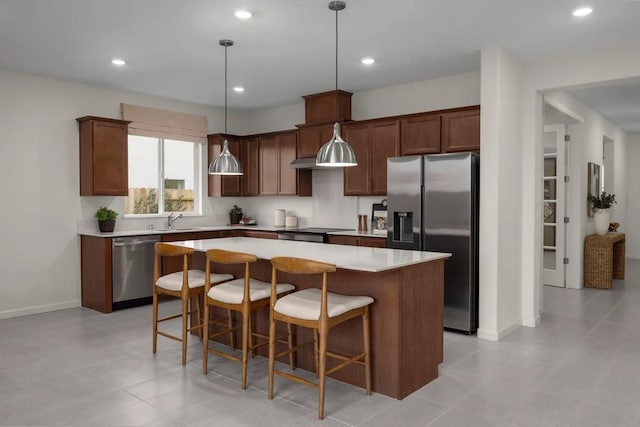 2173 Sylmar Ave, Fresno, CA 93725 - kitchen with stainless steel appliances, a sink, a center island, light countertops, and a kitchen bar