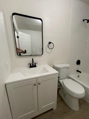 bathroom featuring toilet, vanity, and shower / bathtub combination