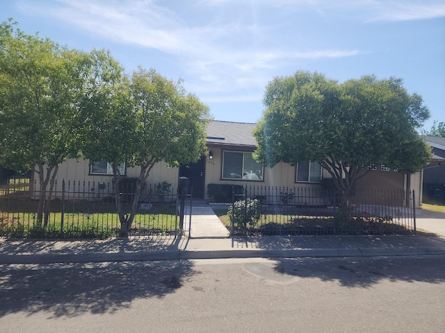 obstructed view of property featuring a fenced front yard and roof with shingles