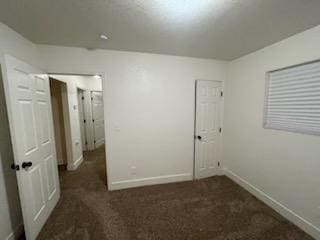 carpeted empty room featuring baseboards