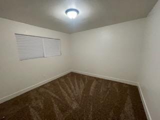 unfurnished room with baseboards and carpet
