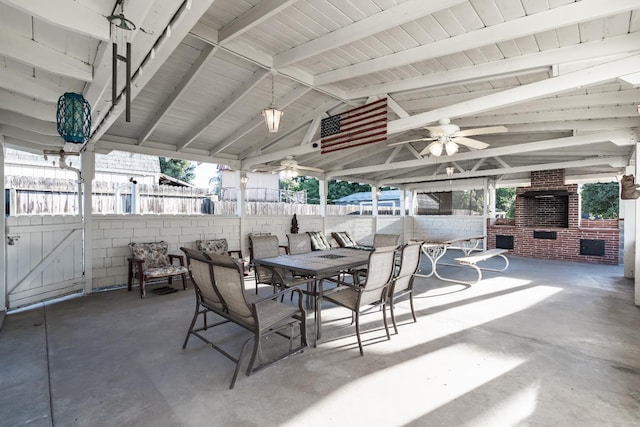 view of patio featuring ceiling fan, fence, a fireplace, and outdoor dining space