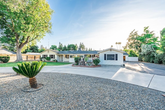 ranch-style house featuring fence and driveway