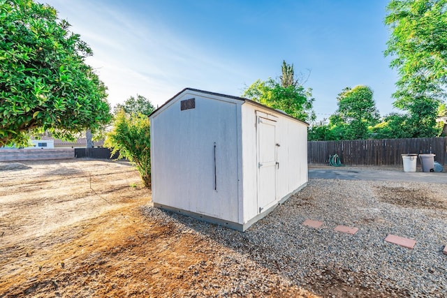 view of shed featuring fence