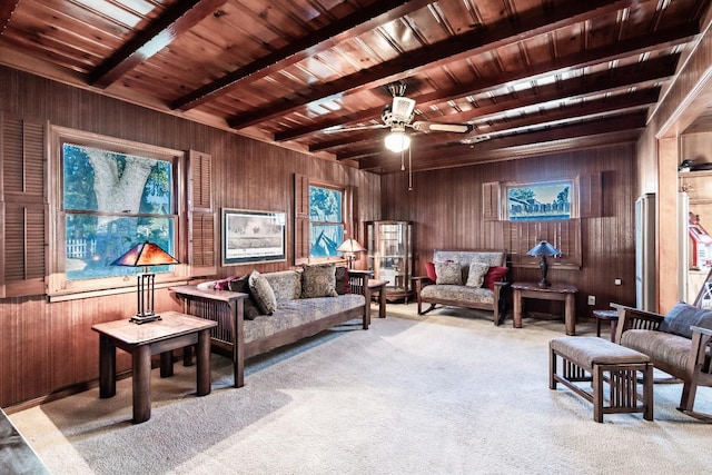 living room with wood walls, beam ceiling, carpet floors, wood ceiling, and ceiling fan