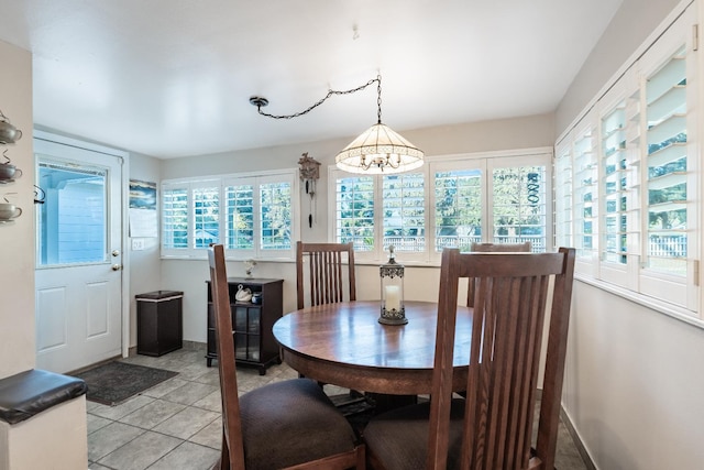dining room with a chandelier, light tile patterned floors, and baseboards