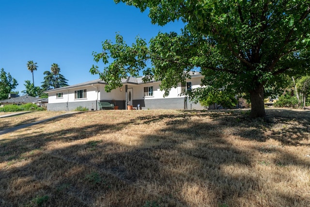 view of front of home with a front yard and stucco siding