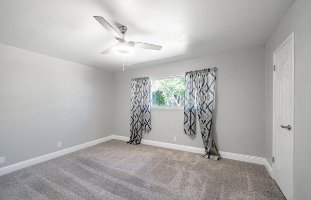 carpeted empty room featuring a ceiling fan and baseboards