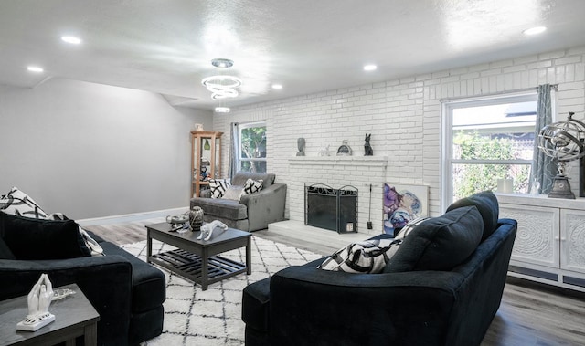 living area featuring light wood-type flooring, a fireplace, baseboards, and recessed lighting
