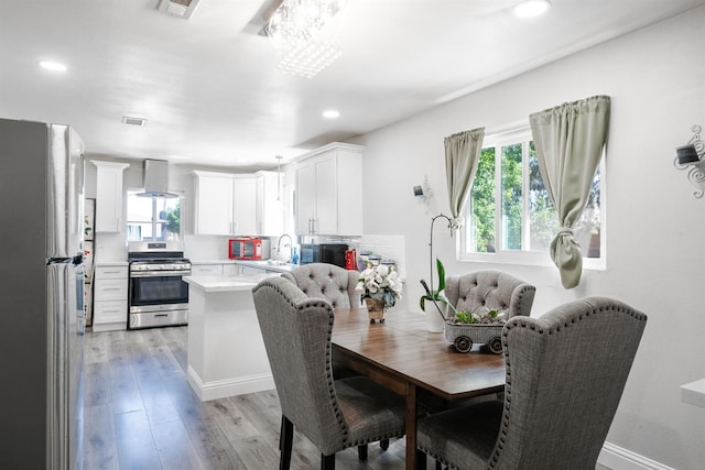 dining area with recessed lighting, light wood finished floors, and a chandelier