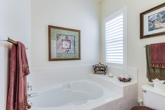 bathroom featuring healthy amount of natural light, toilet, and a garden tub