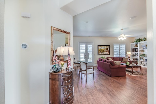 living area featuring wood finished floors, a ceiling fan, and french doors