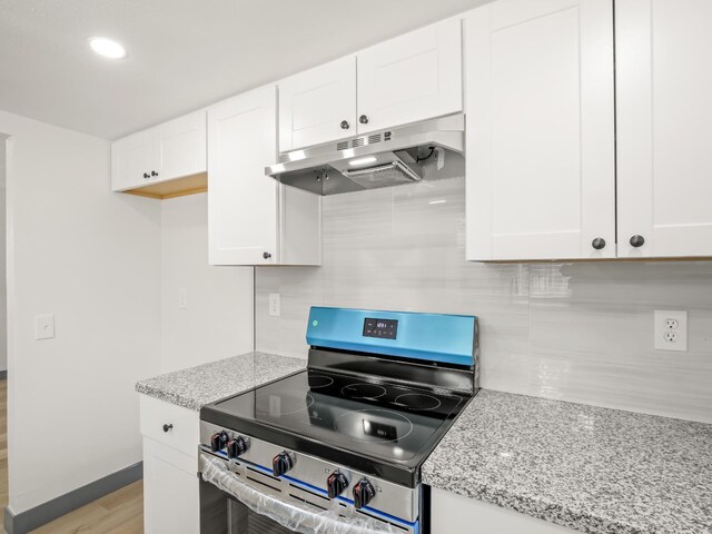4038 W San Jose Ave, Fresno, CA 93722 - kitchen featuring under cabinet range hood, stainless steel range with electric stovetop, decorative backsplash, and white cabinets
