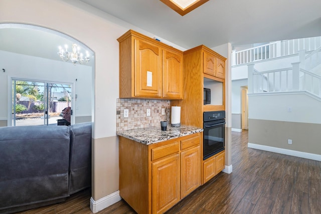 6371 N Babigian Ave, Fresno, CA 93722 - kitchen featuring oven, dark wood finished floors, light stone counters, decorative backsplash, and a chandelier