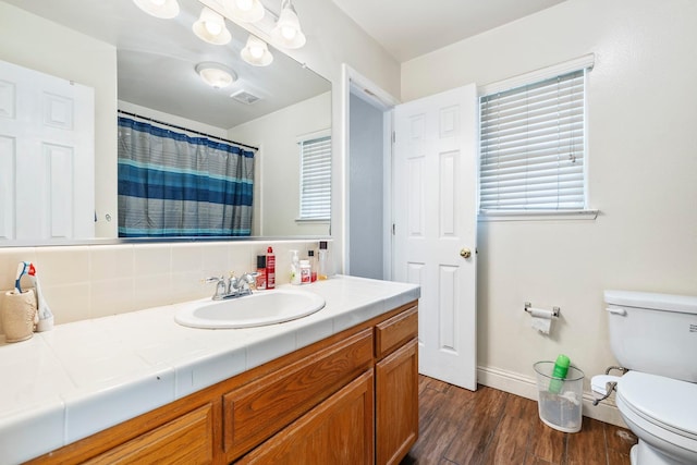 6371 N Babigian Ave, Fresno, CA 93722 - bathroom with toilet, wood finished floors, baseboards, and vanity
