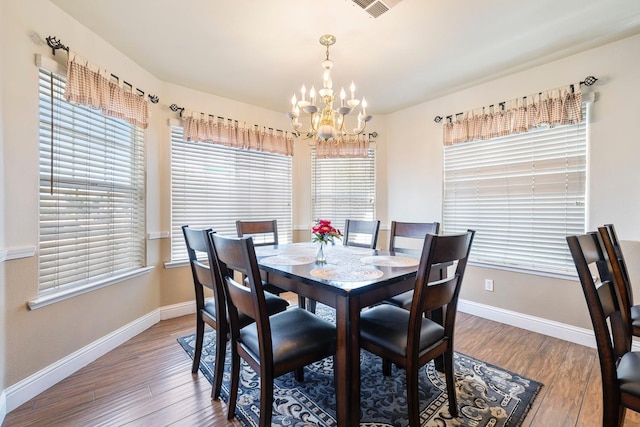 6371 N Babigian Ave, Fresno, CA 93722 - dining room featuring a chandelier, wood finished floors, and baseboards