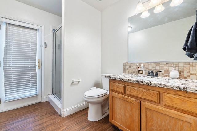 6371 N Babigian Ave, Fresno, CA 93722 - full bath with decorative backsplash, a shower stall, wood finished floors, toilet, and vanity