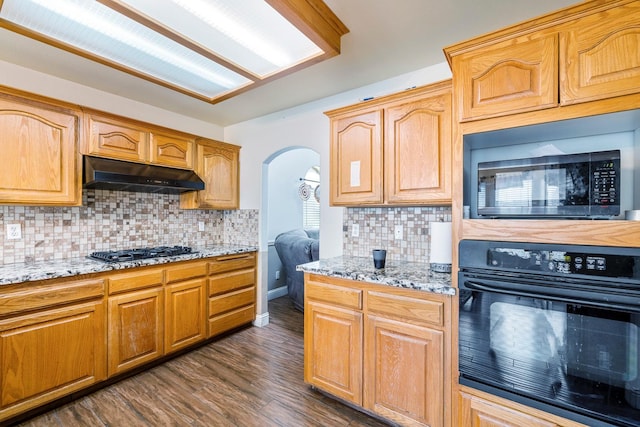 6371 N Babigian Ave, Fresno, CA 93722 - kitchen featuring oven, under cabinet range hood, gas stovetop, light stone counters, and decorative backsplash