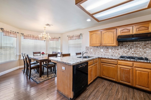 6371 N Babigian Ave, Fresno, CA 93722 - kitchen with black dishwasher, a sink, a chandelier, under cabinet range hood, and baseboards