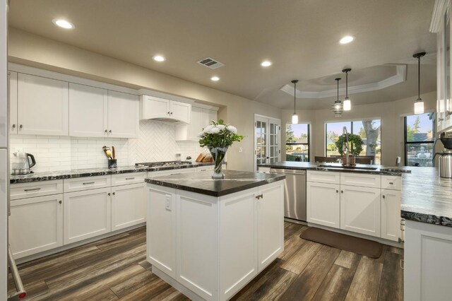525 E Shelldrake Cir, Fresno, CA 93730 - kitchen featuring appliances with stainless steel finishes, a tray ceiling, a center island, dark wood-style flooring, and recessed lighting