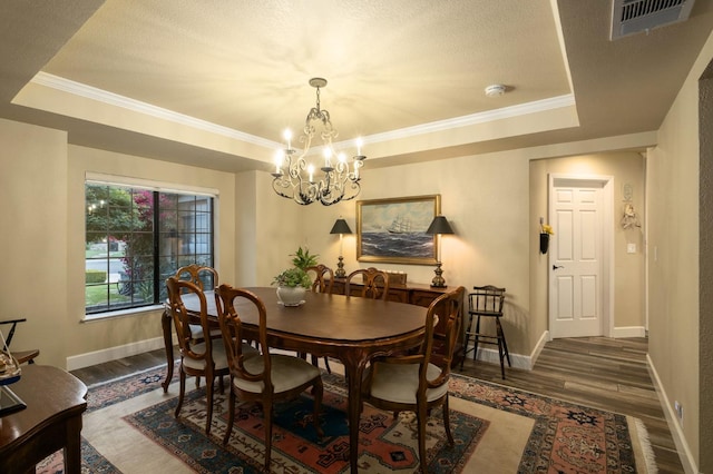 525 E Shelldrake Cir, Fresno, CA 93730 - dining space featuring dark wood finished floors, a tray ceiling, a chandelier, baseboards, and ornamental molding