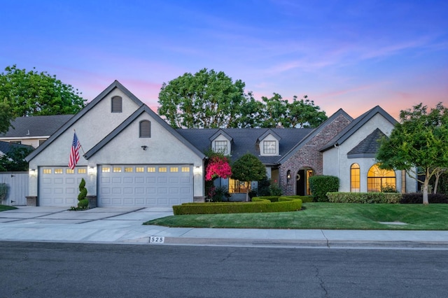 525 E Shelldrake Cir, Fresno, CA 93730 - view of front of property featuring an attached garage, concrete driveway, stucco siding, and a yard