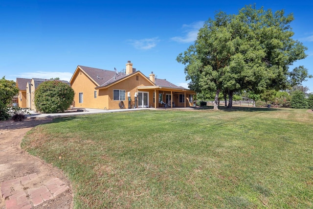 37086 Marciel Ave, Madera, CA 93636 - rear view of house featuring a lawn, stucco siding, a chimney, and a patio