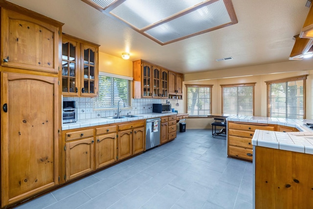 37086 Marciel Ave, Madera, CA 93636 - kitchen with appliances with stainless steel finishes, a sink, brown cabinetry, and tasteful backsplash