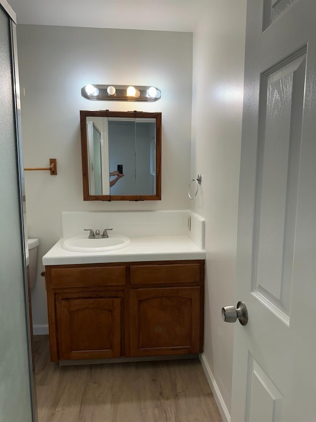 1658 E Paul Ave, Fresno, CA 93710 - bathroom with vanity, wood finished floors, toilet, and baseboards
